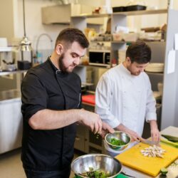 chef and cook cooking food at restaurant kitchen