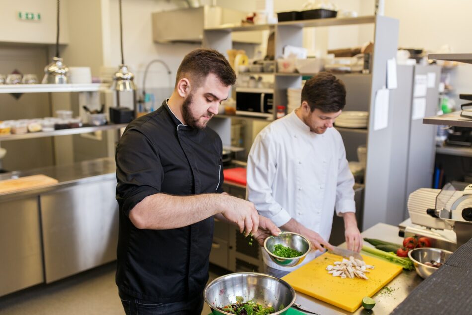 chef and cook cooking food at restaurant kitchen