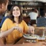 Couple On Date Meeting For Drinks And Food In Restaurant