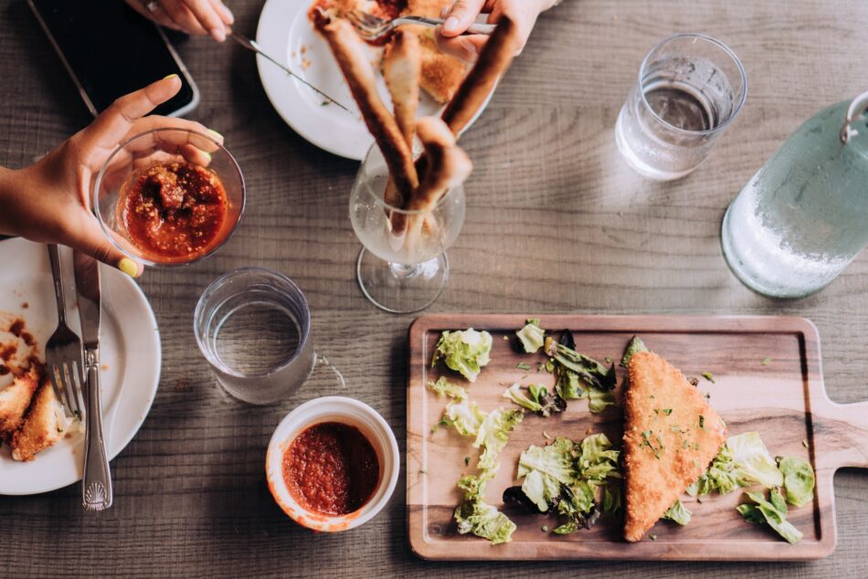 Overhead food flat lay of people having Italian food at restaurant