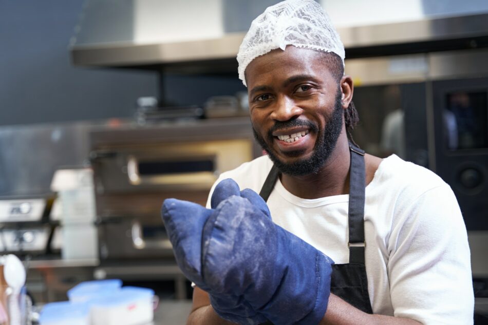 Smiling professional chef baking food in restaurant