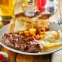 steak and eggs breakfast with toast and homestyle potatoes in restaurant